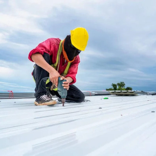 a worker repairing a commercial metal roof