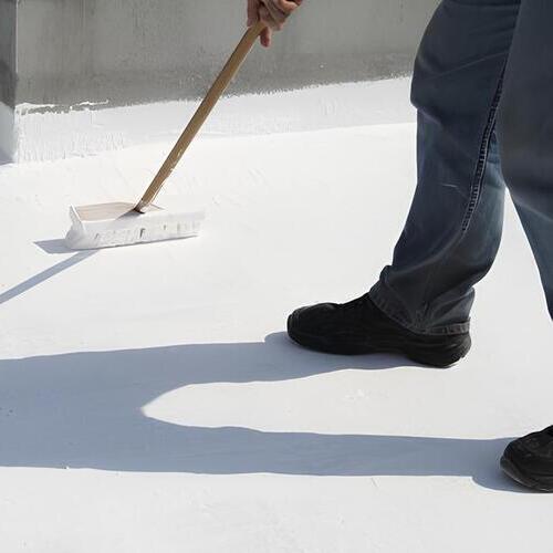 a worker applying a roof coating