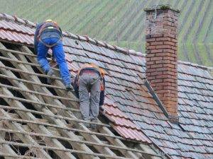 Two people working on roof repair