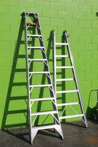 Ladders against a green wall